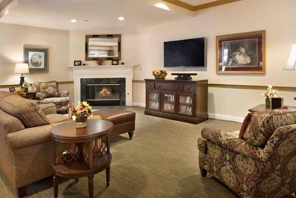 A cozy living room featuring a fireplace, television, and comfortable seating.