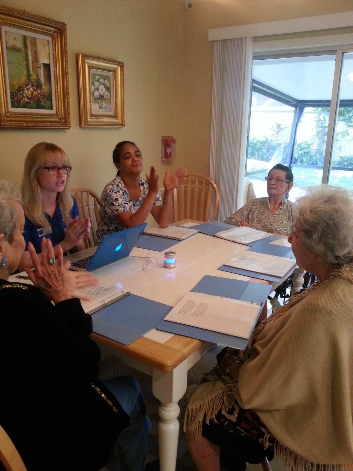 A group of people engaged in a discussion around a table with documents and a laptop.