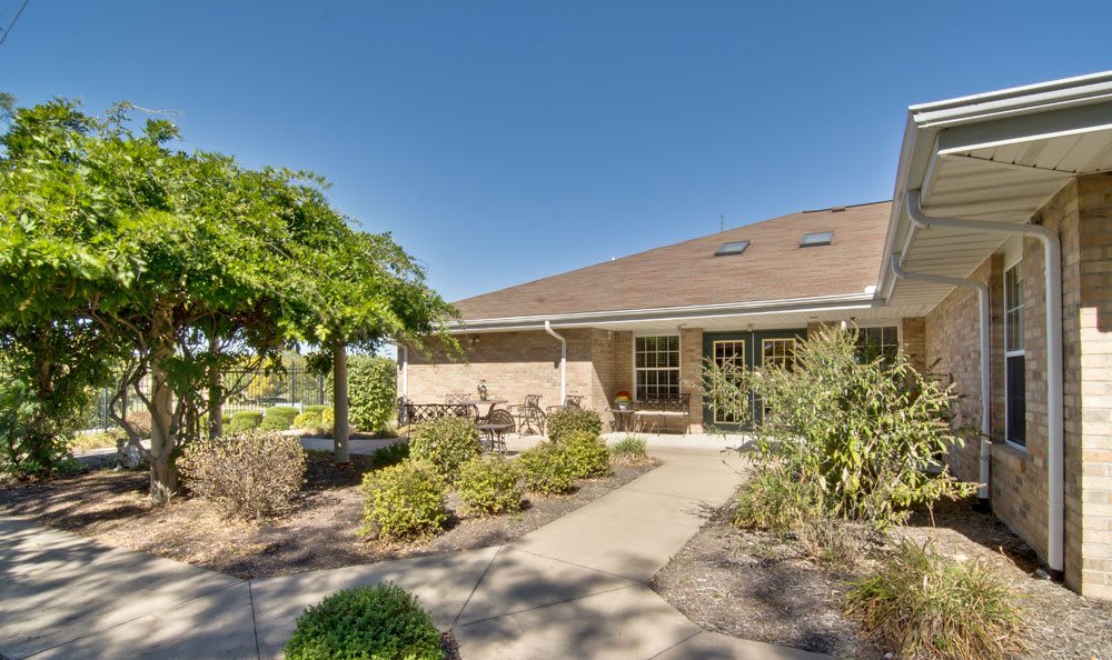 A cozy house with a well-maintained garden and pathway under a clear blue sky.