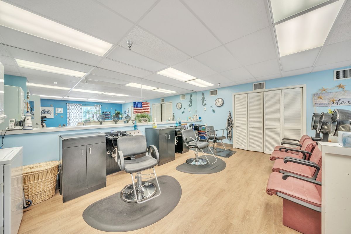 An empty barbershop with chairs and mirrors ready for customers.