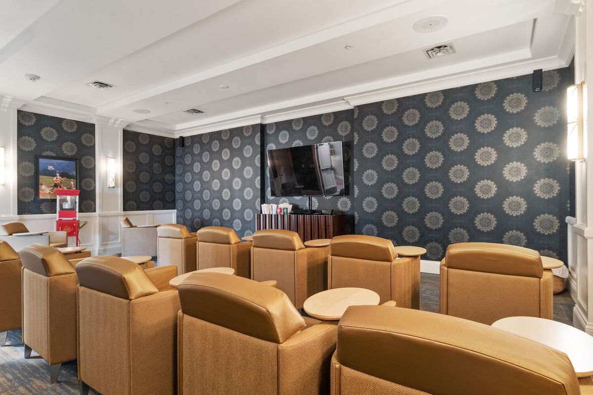 A modern home theater room with comfortable seating and stylish wallpaper.