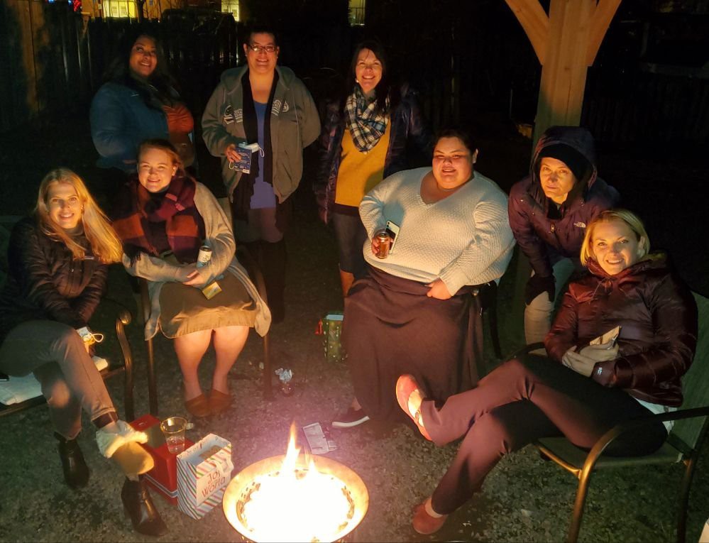 A group of friends enjoying a night around a campfire.