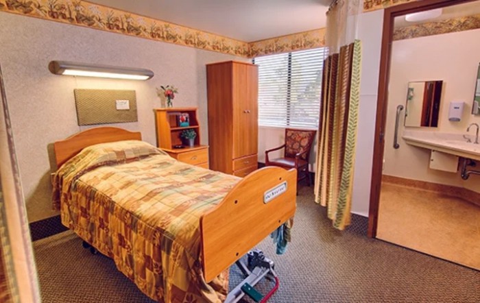A well-organized healthcare room with a bed and furniture.