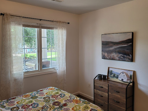 A cozy bedroom featuring colorful bedding and a peaceful view outside.