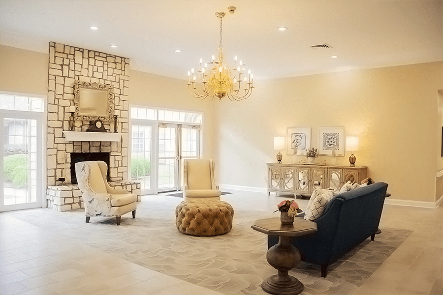 A spacious and elegantly decorated living room with a chandelier and fireplace.