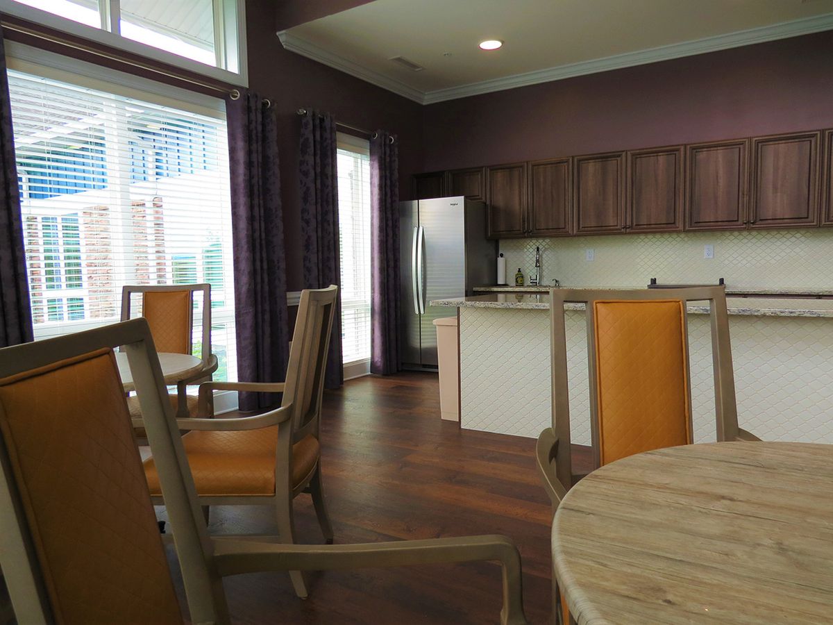A modern kitchen and dining area with wooden furniture and stainless steel appliances.
