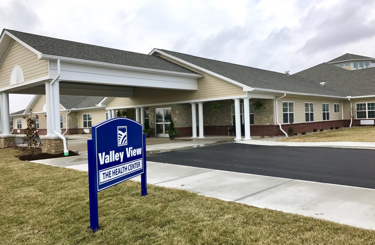 A building with a sign for Valley View, featuring a covered entrance and parking area.