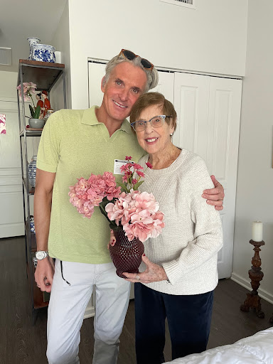 A joyful moment shared between two people with a beautiful flower arrangement.