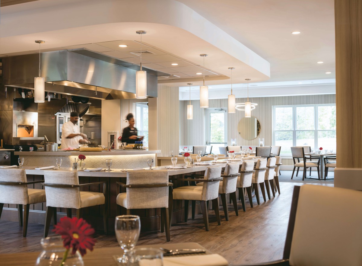 A modern restaurant with an open kitchen and elegant dining area.