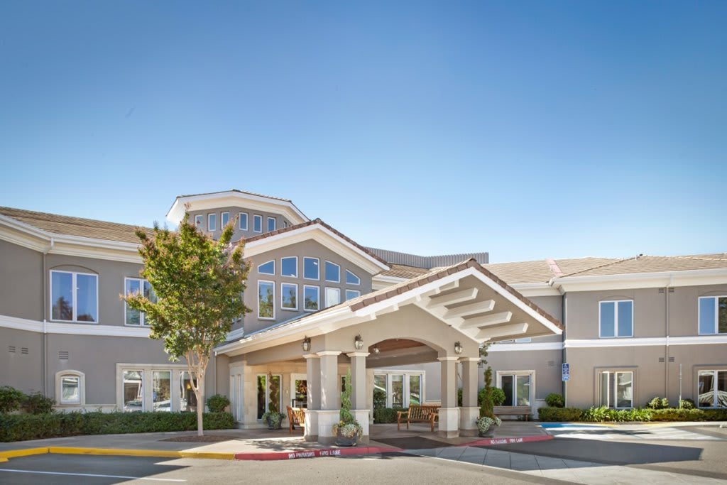 A modern residential building with an inviting entrance under a clear blue sky.