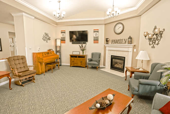 A cozy living room featuring a piano, fireplace, and comfortable seating.