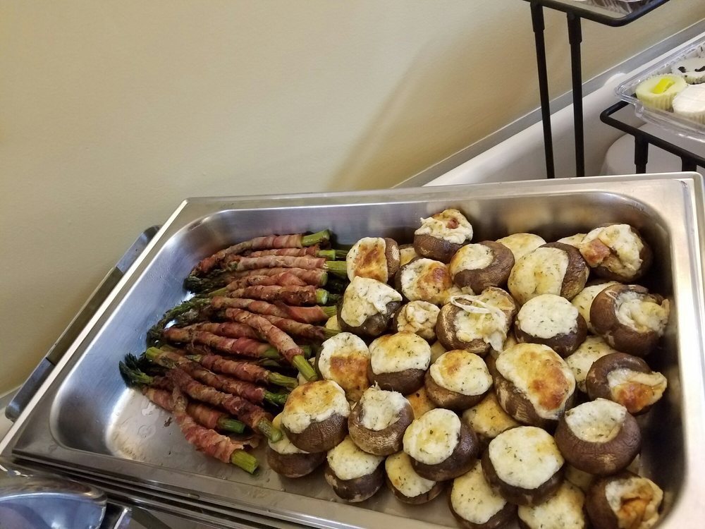 A buffet tray featuring bacon-wrapped asparagus and stuffed mushrooms.