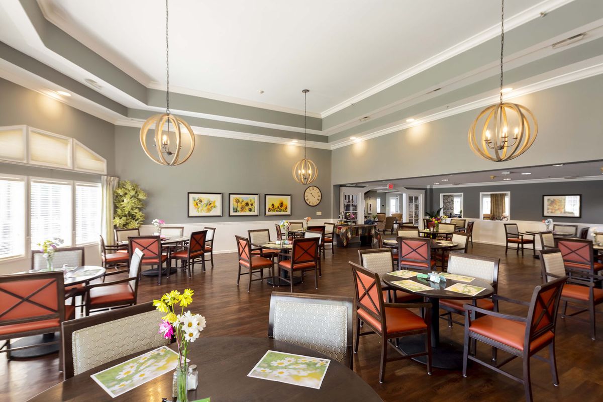 A modern dining area with elegant lighting, hardwood floors, and artwork adorning the walls.