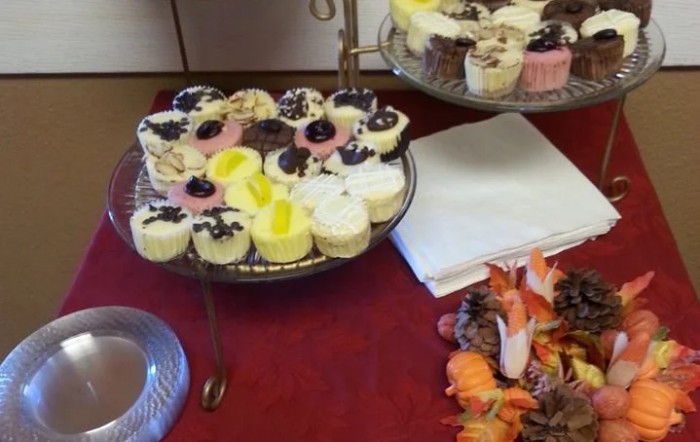 A variety of colorful cupcakes displayed on a tiered stand at a buffet.