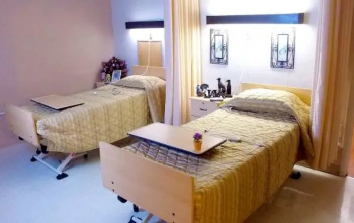 A hospital room with two patient beds separated by a curtain, showcasing a clean and organized medical facility.