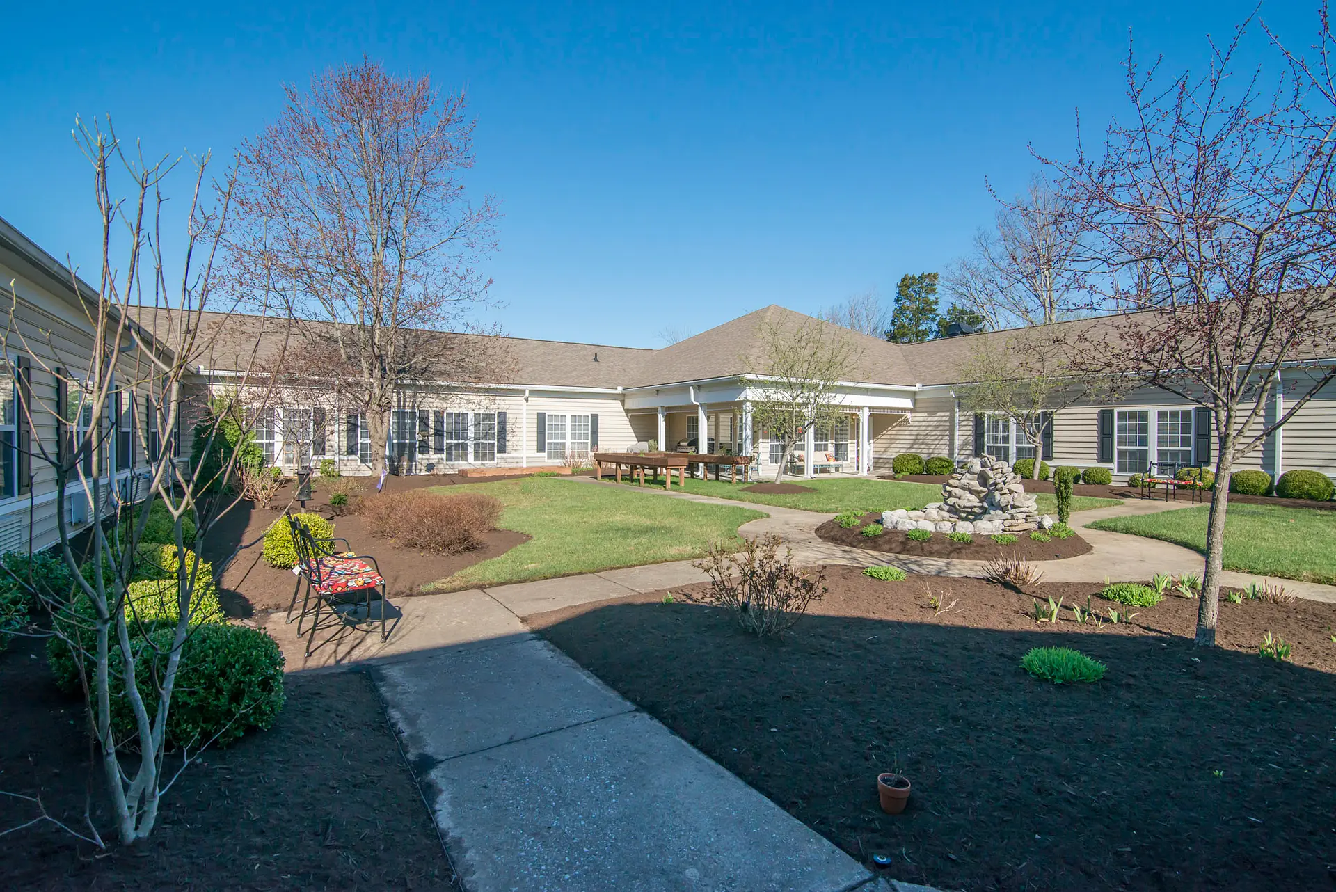 A spacious house with a well-maintained garden and pathway under a clear blue sky.