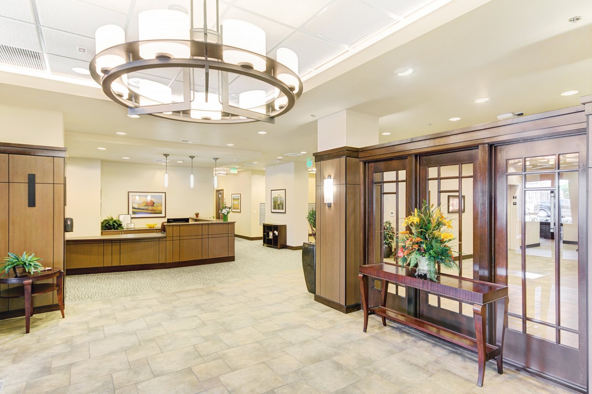 A spacious and elegantly designed lobby with a large reception desk and modern lighting.