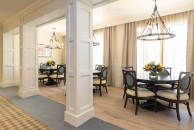 A modern dining area with elegant furnishings and chandeliers.