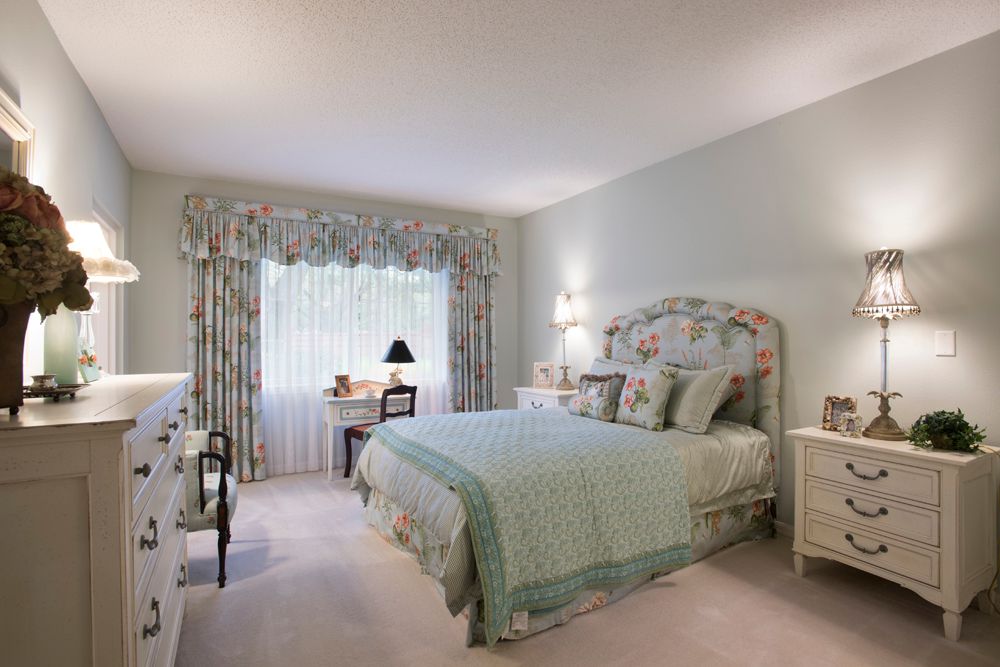 A cozy bedroom with pastel colors and floral decorations.
