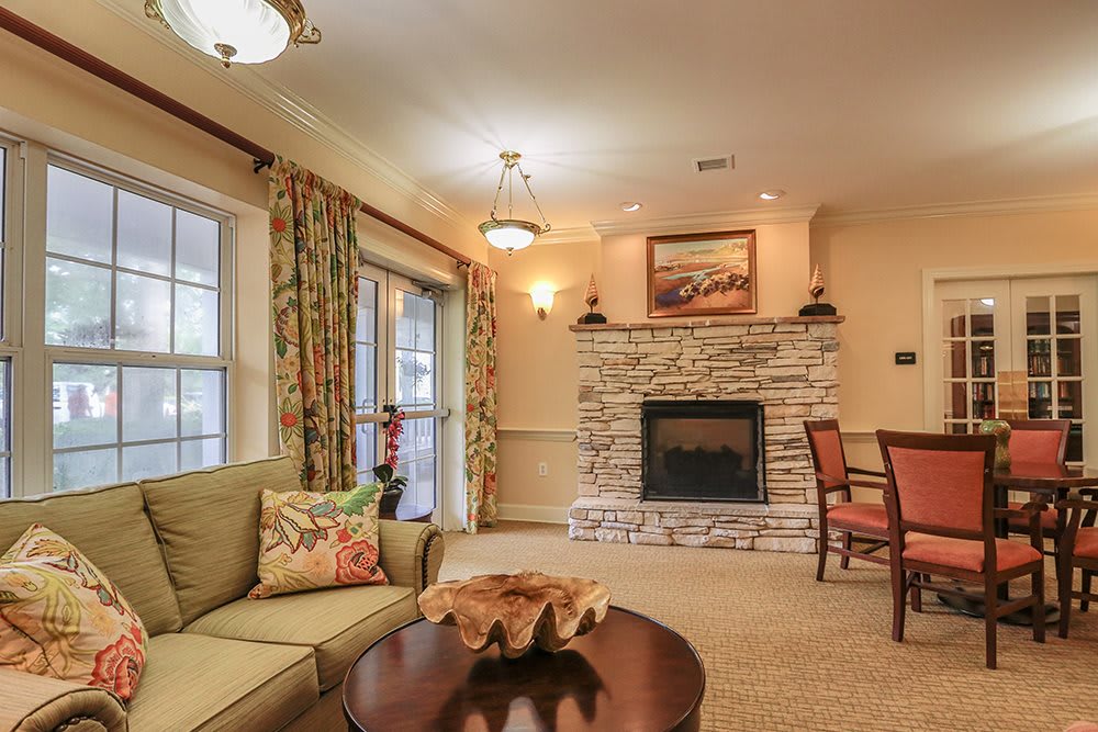 A cozy living room featuring a stone fireplace, comfortable sofa, and elegant decor.
