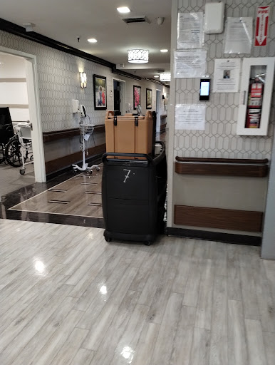A suitcase and boxes waiting in a hospital corridor.