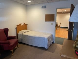 A simple bedroom with a single bed and minimal furnishings.