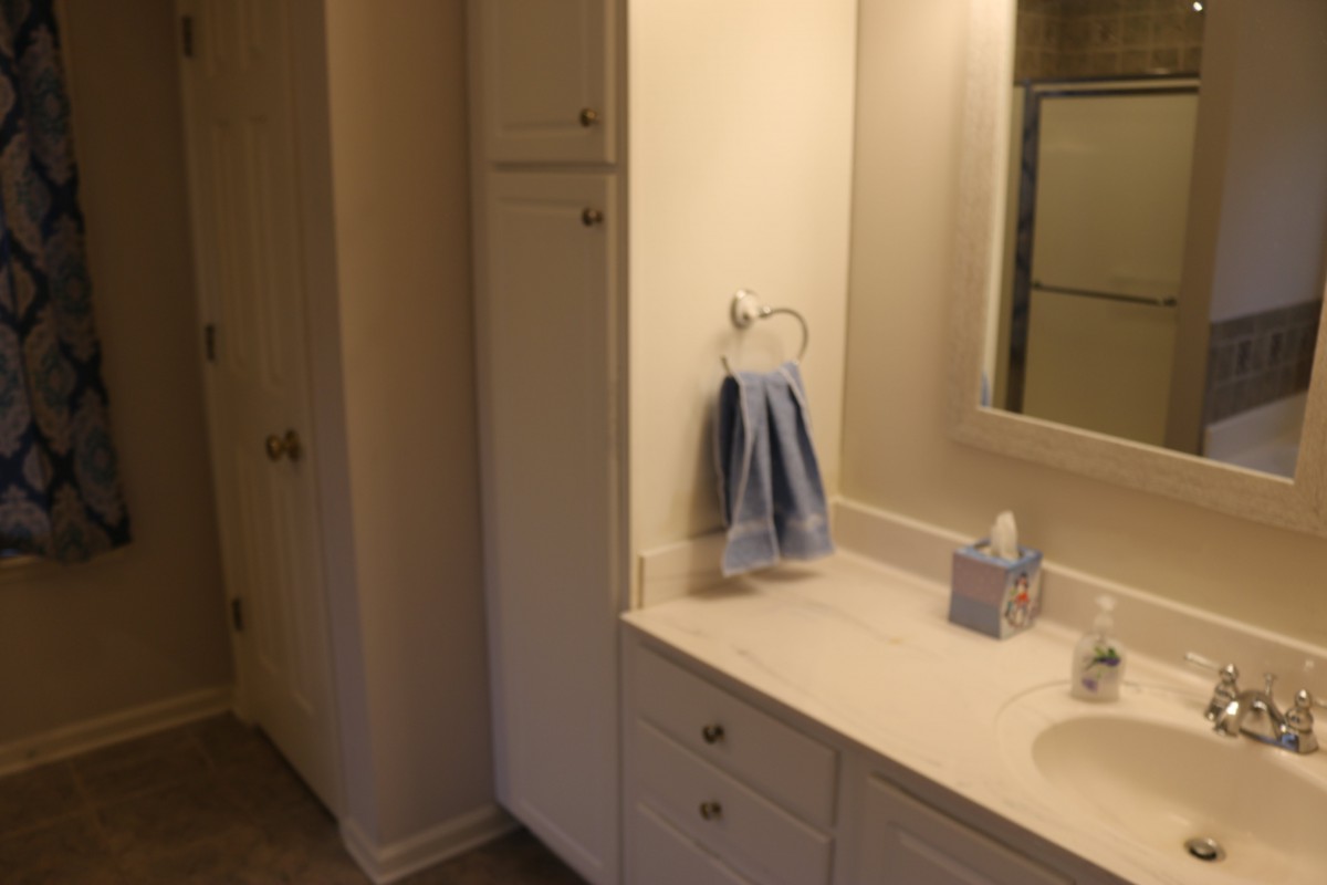 A clean bathroom with a sink, mirror, and towel.