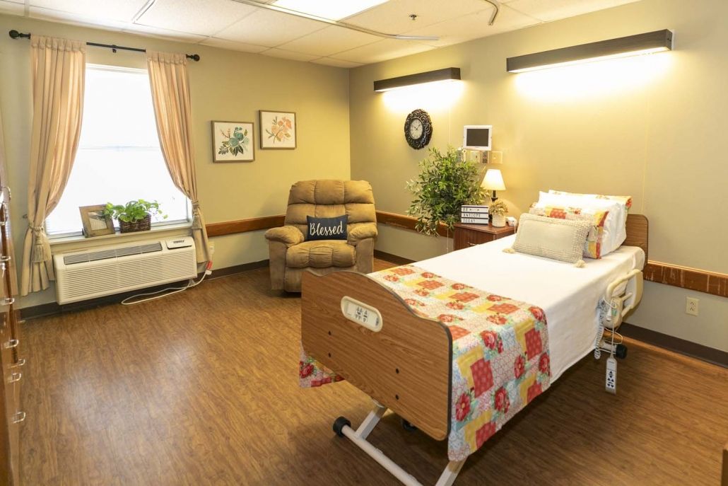 A cozy bedroom with a hospital bed and comfortable seating area.