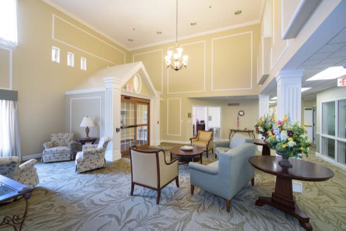 A well-lit living area featuring comfortable seating, a chandelier, and elegant decor.