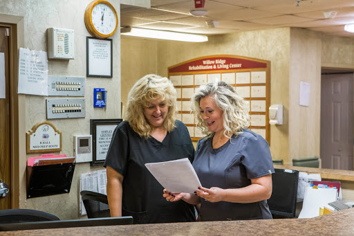 Two healthcare staff members collaborating at the reception desk.