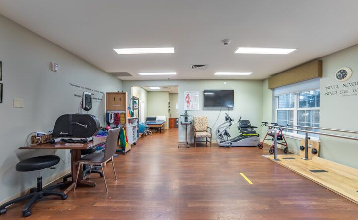 A spacious rehabilitation center with various therapy and exercise equipment.