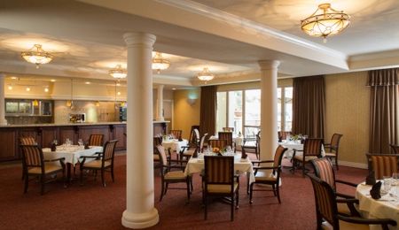 A spacious and elegantly designed restaurant dining area with neatly arranged tables and chairs.