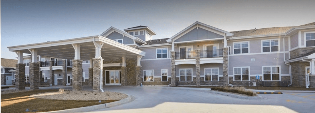 A modern residential building with a driveway and covered entrance.