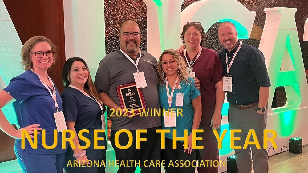 A group of people celebrating the 'Nurse of the Year' award at the Arizona Health Care Association event.