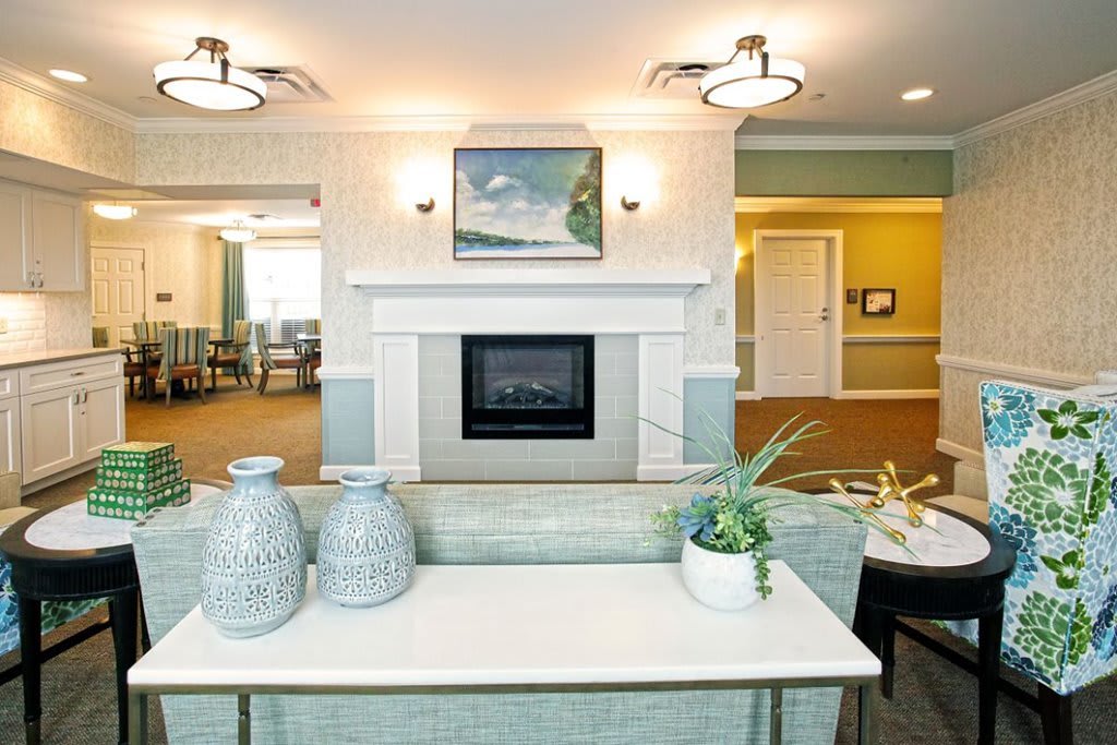 A modern living room with a fireplace, decorative vases, and artwork on the wall.