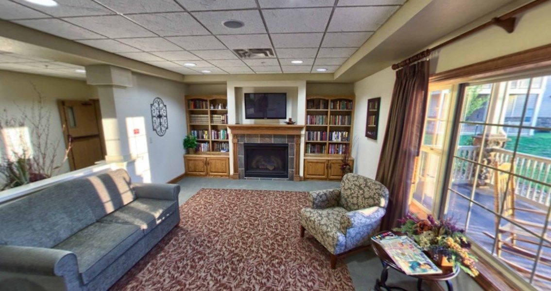 A cozy living room with a fireplace, bookshelves, and comfortable seating.