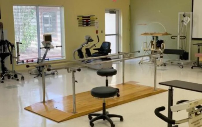 A well-equipped physical therapy and rehabilitation room with various exercise equipment.