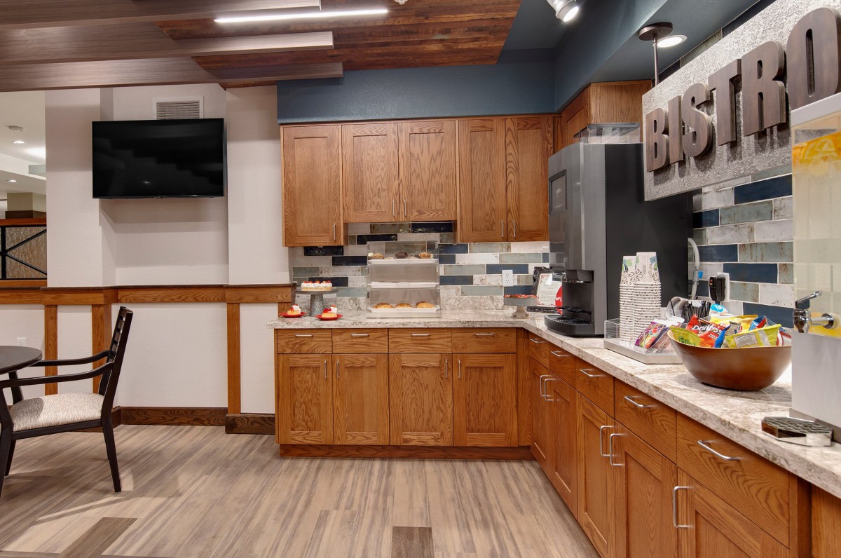 A modern kitchen setup with wooden cabinets and a coffee station on the countertop.