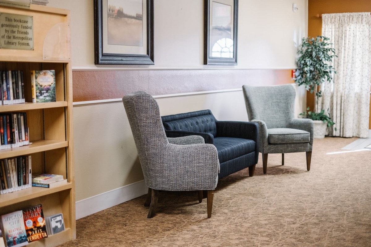 A cozy waiting room with comfortable chairs and framed artwork on the walls.