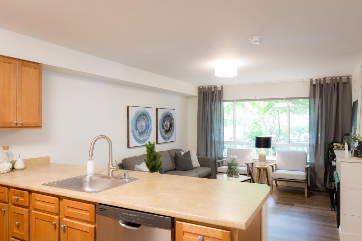 A modern, bright apartment featuring an open-concept living room and kitchen area with stylish decor.