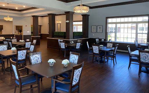 A spacious and elegantly designed dining area featuring modern furniture and bright natural light.