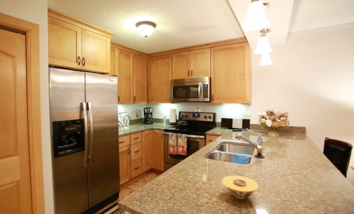 A modern kitchen with wooden cabinets and stainless steel appliances.