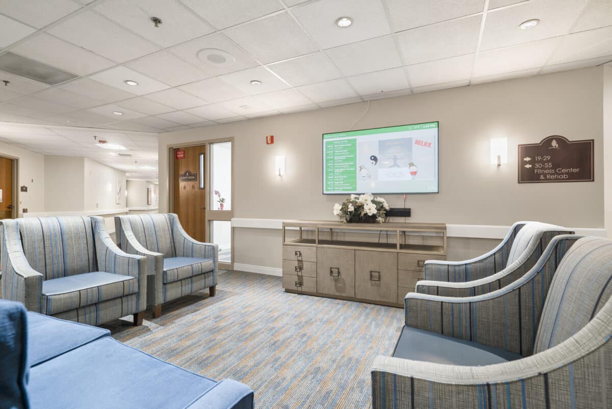 A modern waiting room with comfortable seating and a television.