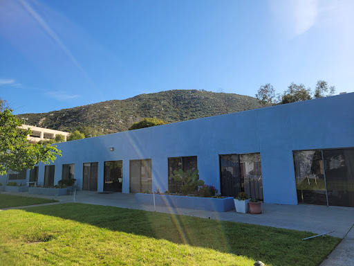 A blue building set against a mountain under a clear sky.