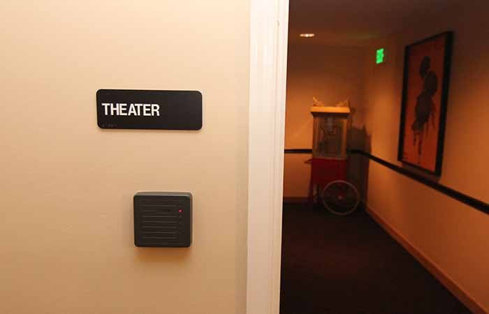 Entrance to a theater with a popcorn machine visible in the hallway.