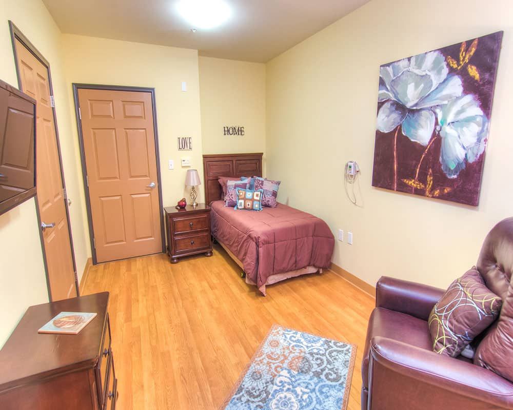 A cozy bedroom with a single bed, nightstand, and artwork on the wall.