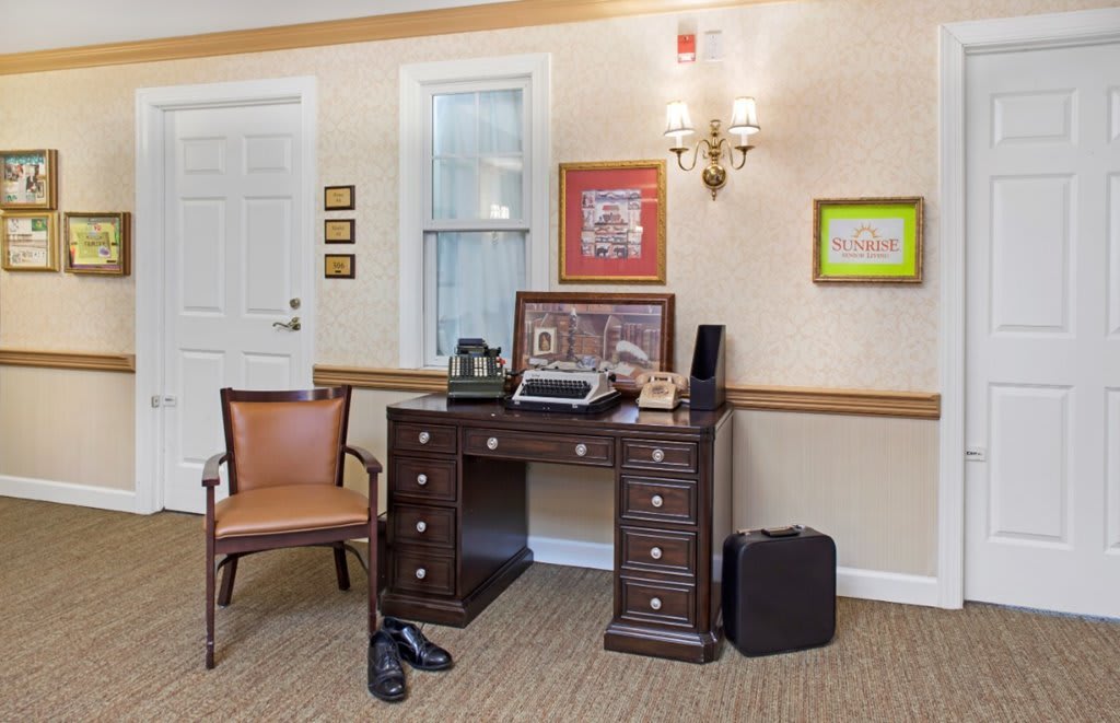 A vintage-styled office setup featuring a wooden desk with a typewriter and decorative items.