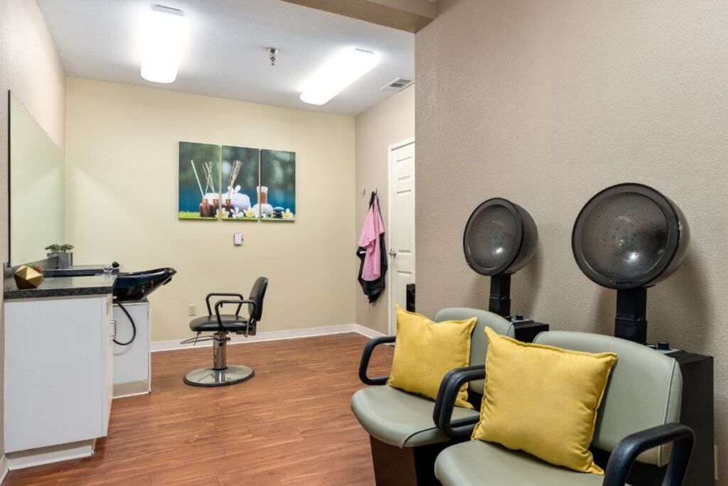 A cozy hair salon interior with seating and hair drying stations.