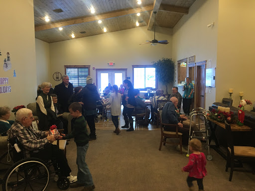 A community gathering taking place indoors with a mix of adults and children.