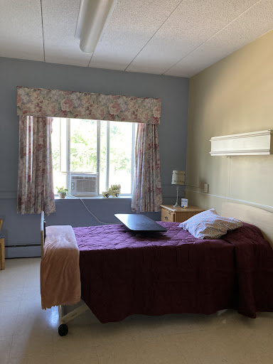 A serene hospital room featuring a bed, window with curtains, and minimalistic decor.